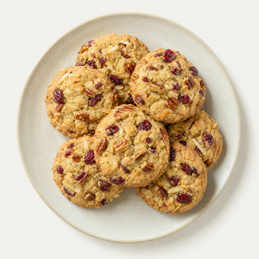 Pecan coconut cranberry cookies on a cream plate, overhead
