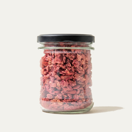 Twice-baked sprouted superfood granola in a glass jar with black cap
