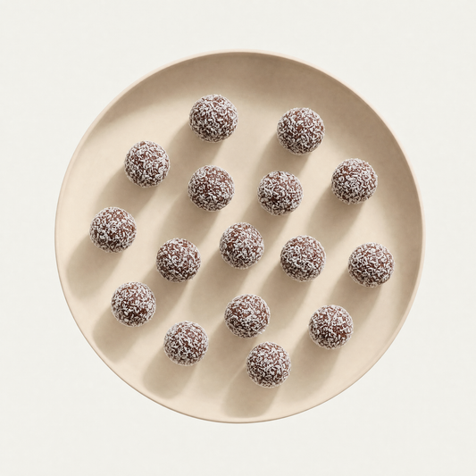 Hazelnut chocolate bliss balls on a cream plate, overhead